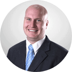 alt="Circle head shot of Todd Palmer, insurance advisor at Inside Insurance, in black suit and blue necktie."